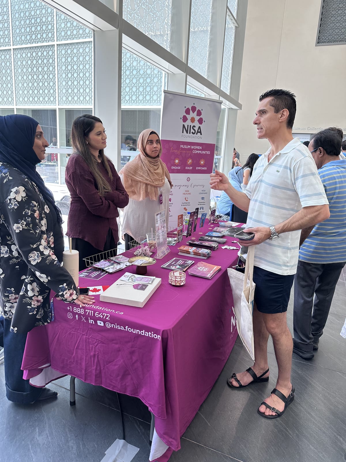 Sinan Erdemir visiting a community organization's booth at a cultural event in Toronto