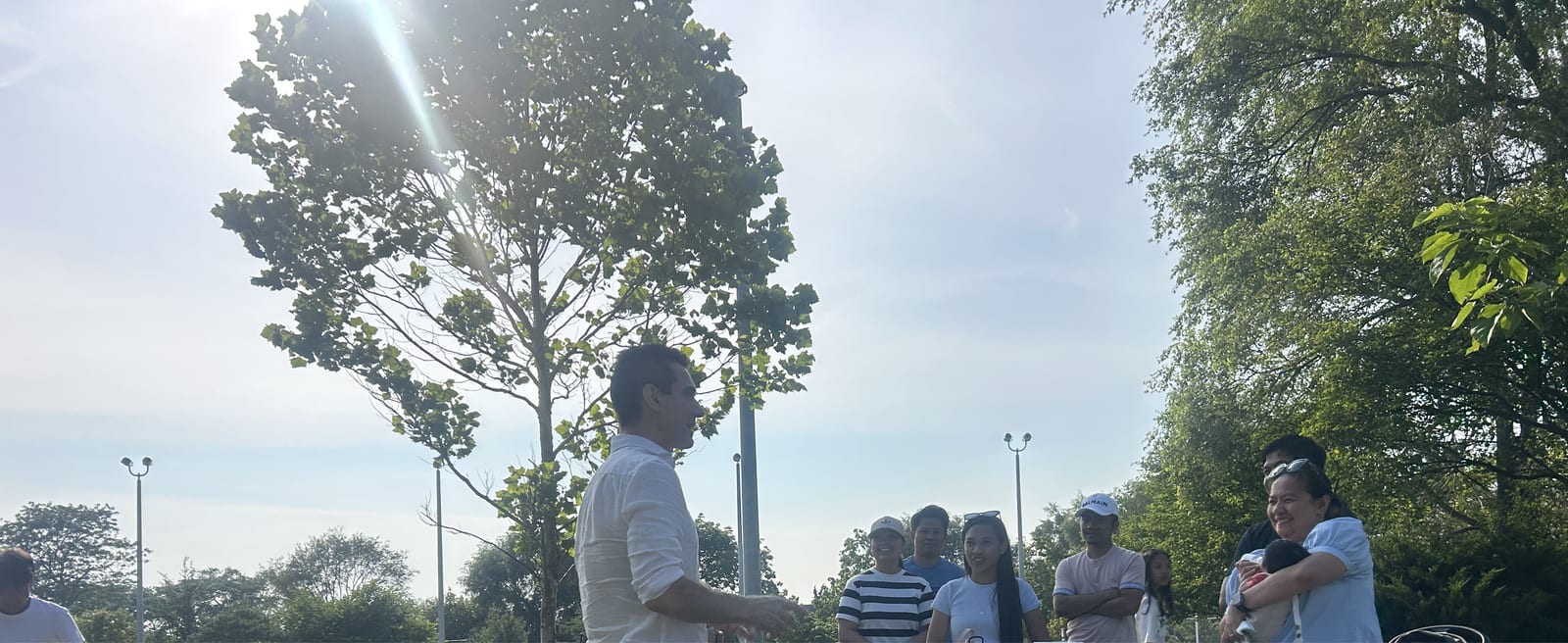 Sinan Erdemir speaking with a group of neighbours at a park gathering