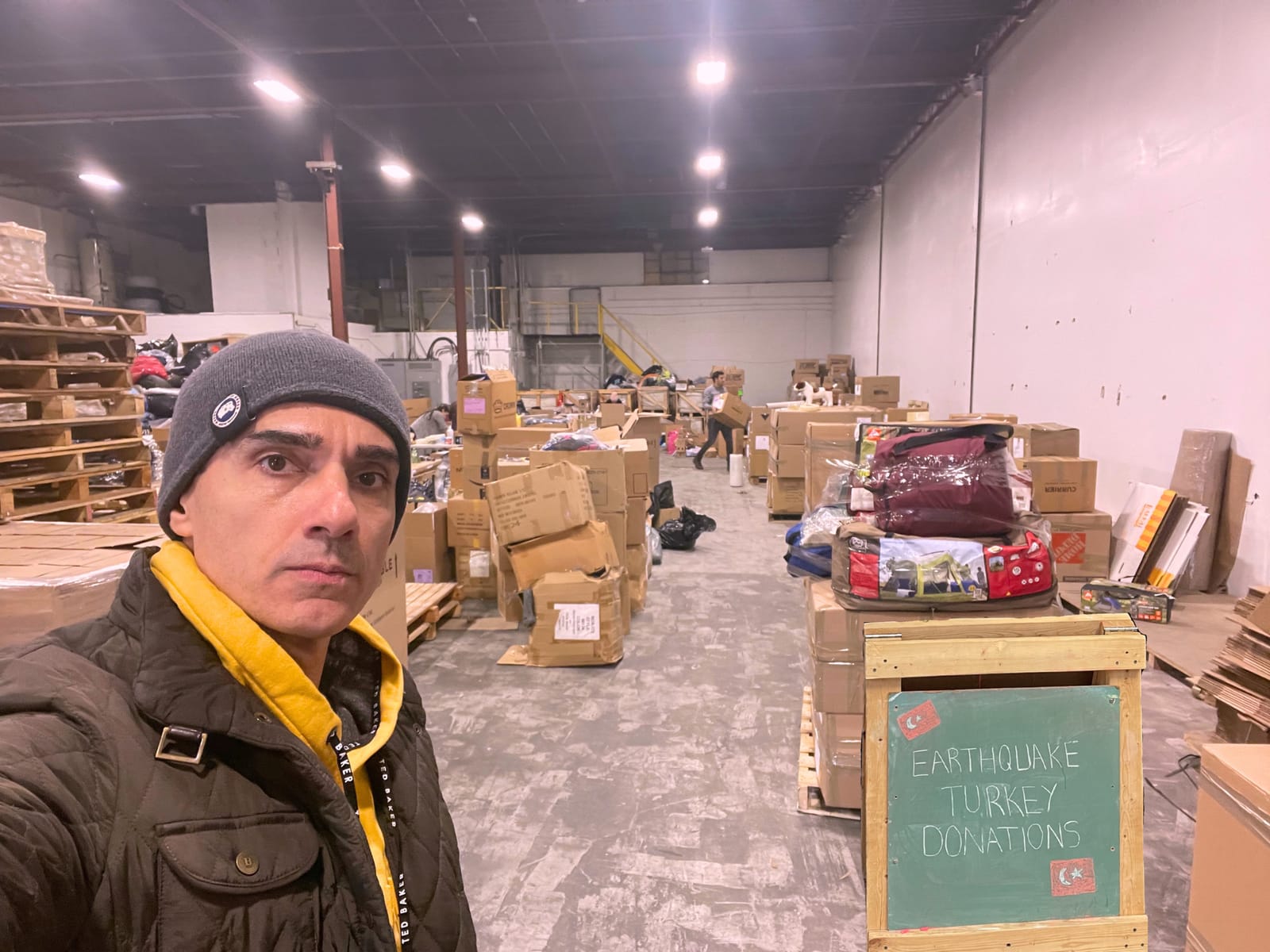Sinan Erdemir volunteering at a warehouse collecting earthquake relief donations for Türkiye