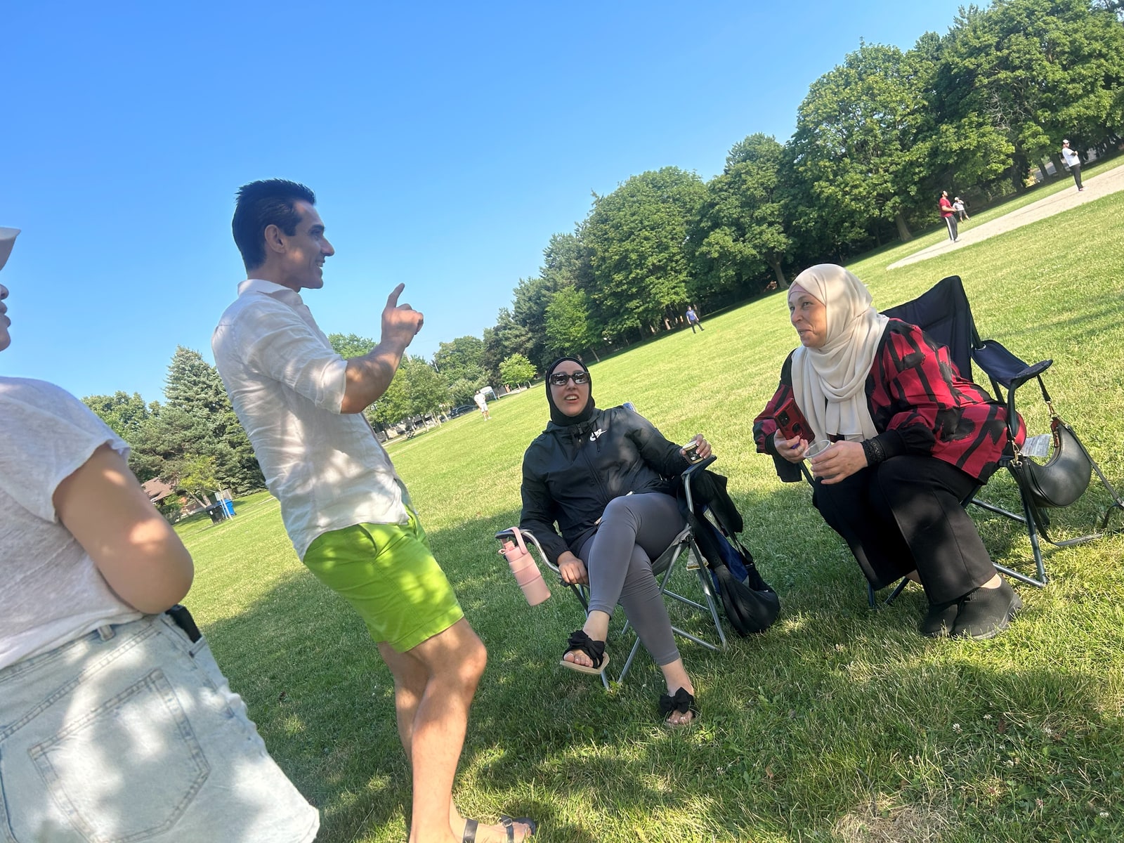Sinan Erdemir in conversation with residents at a summer park gathering